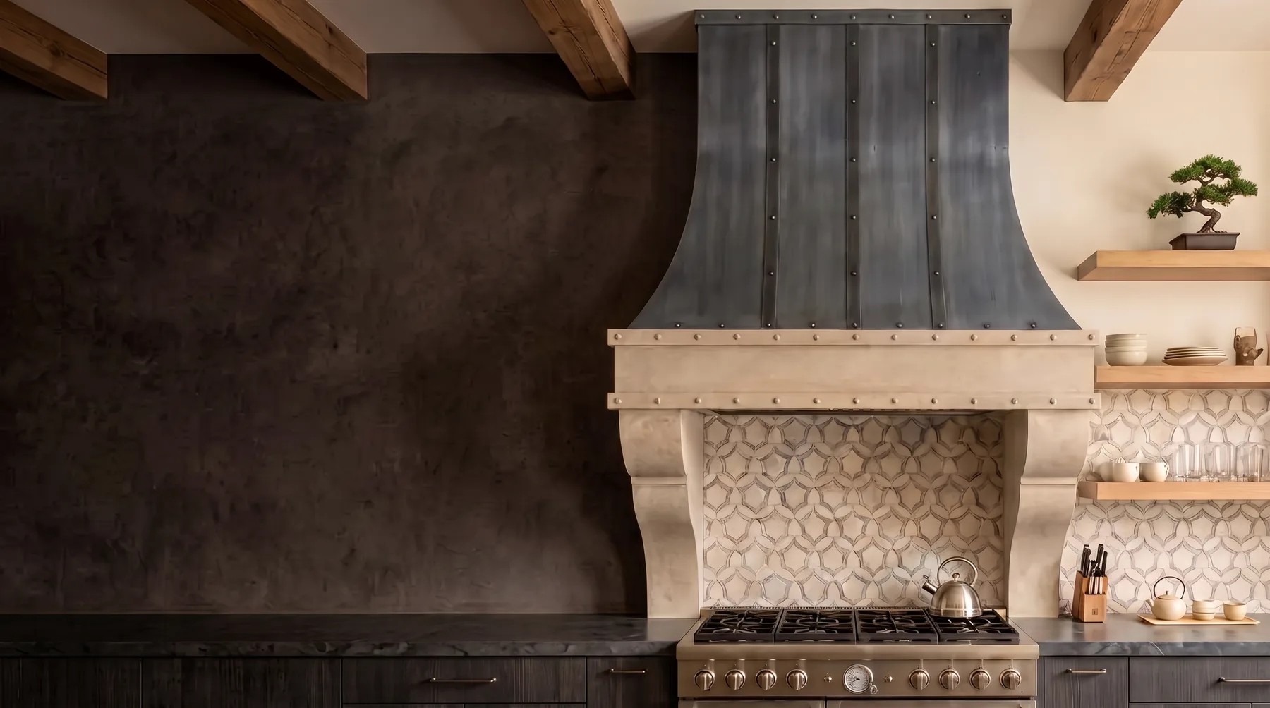 Cast stone kitchen range hood with a zinc canopy above a professional range
