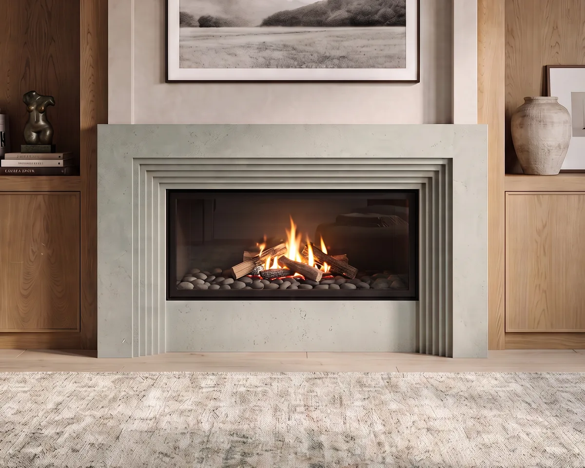 Soft sage-grey cast stone fireplace mantel with a stepped reveal surround and long linear firebox